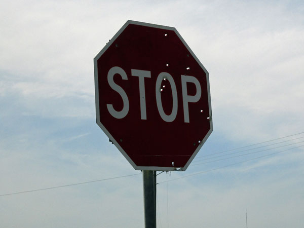 a stop sign all full of bullet holes somewhere in mississippi on october 17, 2015